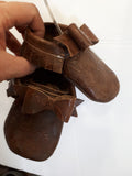 Floral embossed brown leather moccs with short fringe and bows