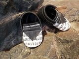 Black or grey leather moccs with short fringe and music toe toppers.