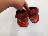 Red leather moccs with short fringe and bows